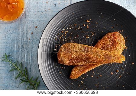 Seasoned Chicken With Hot Sauce And A Sprig Of Rosemary