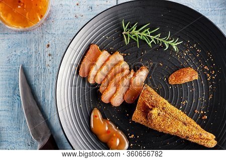Seasoned Chicken With Hot Sauce And A Sprig Of Rosemary