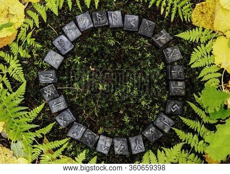 A Circle Of 24 Scandinavian Runes On The Background Of Moss And Leaves In The Autumn Forest.