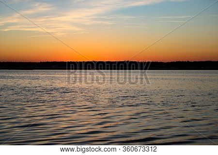 Beautiful Landscape View With River Slowly Flowing With Small Waves During The Sunset. Photo Taken I