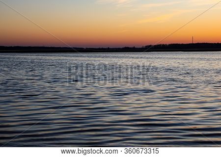 Beautiful Landscape View With River Slowly Flowing With Small Waves During The Sunset. Photo Taken I