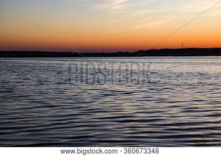Beautiful Landscape View With River Slowly Flowing With Small Waves During The Sunset. Photo Taken I