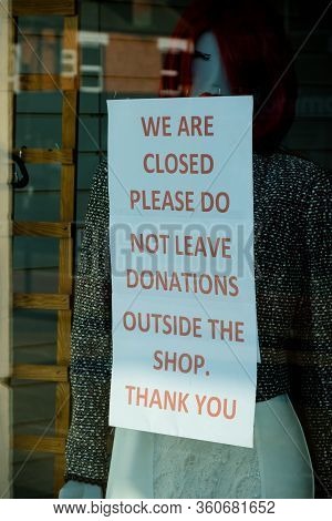 Sandhurst, United Kingdom, 9th April 2020:- A Sign Outside A Charity Shop After It Has Closed Asking