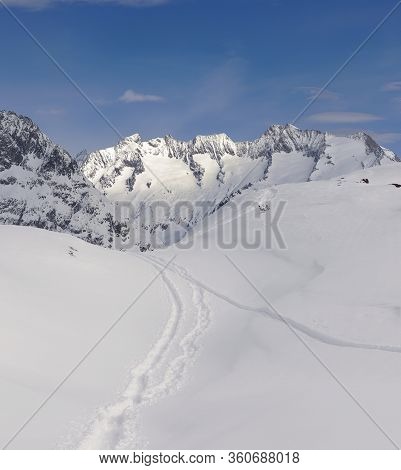 Mountain Winter Scenery With Ski Tracks Through Powder Snow. Swiss Mountains Wannenhorn Gabelhorn In