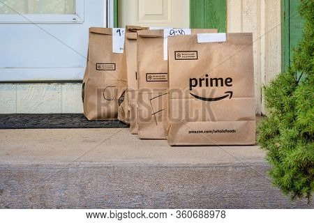 Fort Collins, CO, USA - March 31, 2020: Brown bags with groceries delivered to home from Whole Food Market and ordered through Amazon Prime. Online shopping during coronavirus pandemic.