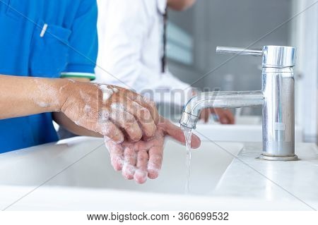 Man is washing his hands in a sink sanitizing the colona virus for sanitation and reducing the sprea