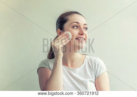 Beauty Portrait Of Smiling Woman With Soft Healthy Skin Removing Make Up With Cotton Pad Isolated On