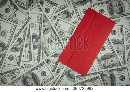 Chinese Blank Red Envelope Or Hong Bao On A Group Of Money Stack Of 100 Us Dollars Banknotes A Lot O