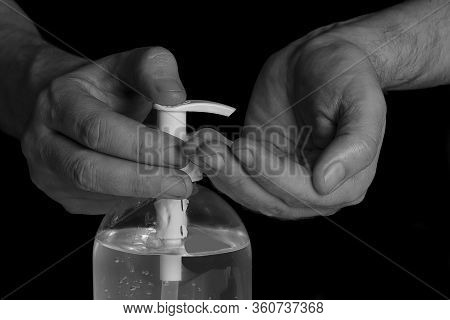 Picture Black & White Of Hands In Foreground Using A Recommended Hygiene Gel To Prevent Any Posibili