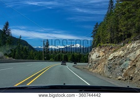 Mountain View From Sea To Sky Hgw, Cars Going Down The Highway Against The Background Of A Forest, A