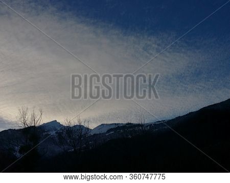 Clouds In A Sunny, Windy Sky. Play Of Light Between Mountain Shadows, Cloudy Skies In Blue And White
