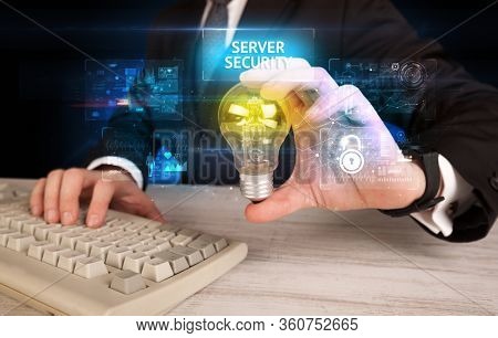 Businessman holding lightbulb with SERVER SECURITY inscription, online security idea concept