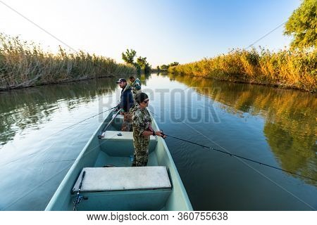 Anglers fishing from the boat on the calm river in Astrakhan Region in Russia. Astrakhan is a famous fishing destination