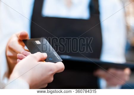 Closeup Woman Barista, Waiter In Brown Apron Uniform Is Holding Tablet Computer, Taking Credit Card 