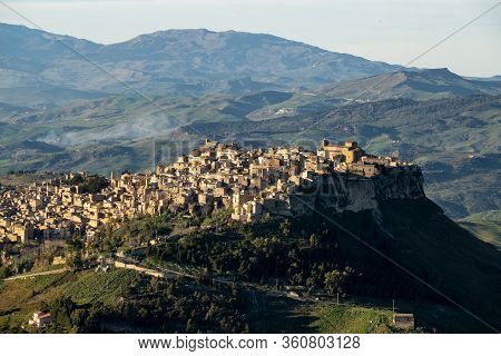 Sicilian Landscape With The City Of Calascibetta At Nice Sunset With Black Shadows
