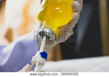 Anesthesiologist Doctors Hand Inject I.v. Drip Set Into Normal Saline Solution (nss) Bottle,coronavi