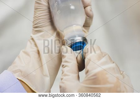 Anesthesiologist Doctors Hand Is Opening Normal Saline Solution (nss) Bottle,coronavirus Treatment C
