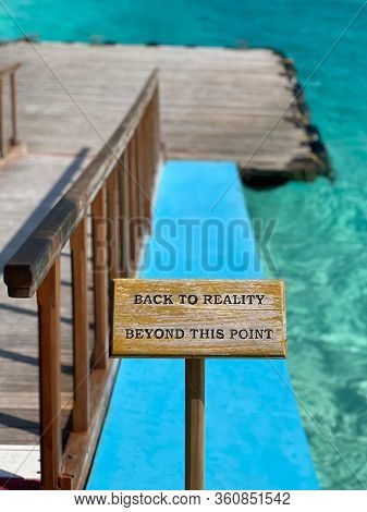 Wooden Sign Is On The Beach Telling Us To Relax