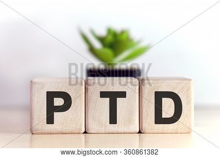 Ptd Concept On Wooden Cubes And Flower In A Pot In The Background