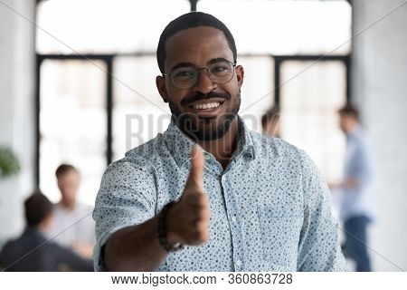 Smiling Biracial Businessman Welcoming New Employee At Workplace