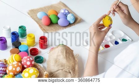 Happy Asian Woman Painting Eggs For Eastertime At Home. Family Preparing For Easter.