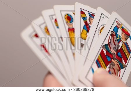 Split Croatia, May 2020
A Hand Holding Several Italian Old Playing Cards. Popular Game In The Medite