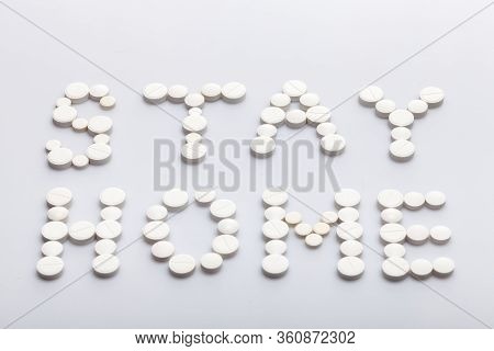 Stay Home Inscription Made Of Round White Pills On A White Background, Medical Concept On The Theme 