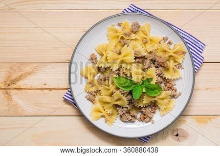 Ready-to-eat Pasta Navy With Minced Meat And Basil Leaves On A Plate On A Wooden Table. Russian Cuis