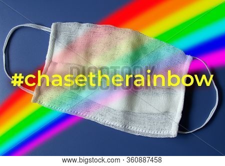 The Concept Of The Pursuit Of The Rainbow. Medical Mask In All Colors Of The Rainbow On A Blue Backg