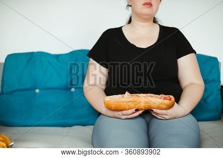 Overeating And Gluttony Concept. Mindless Snacking, Home Sedentary Lifestyle. Obese Woman Sitting On
