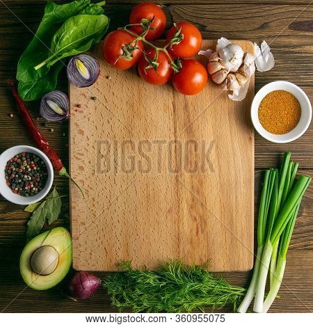 Wooden Board With Clear Space. Around Tomato And Dill, Olive Oil, Peper, Avocado, Green Onion, Spina