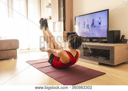 A Young Woman Doing Push-ups In Her Living Room In The Covid19 Quarantine