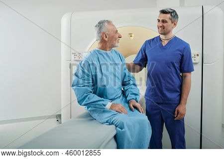 Radiographer Talking With Male Patient In Hospital Radiology Department Prior To Ct Scan Being Perfo
