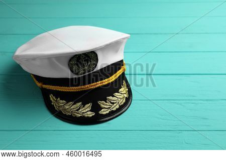 Peaked Cap With Accessories On Turquoise Wooden Background, Space For Text