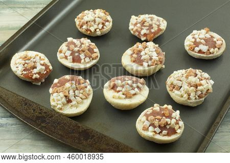 Frozen Miniature Bite Size Pizza Snack Pieces With Tomato Sauce And Cheese Cubes On Baking Sheet Pan
