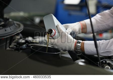 Mechanical Filling Of Oil Into Car In Repair Garage. Changing Oil In Engine Of Car Service Center