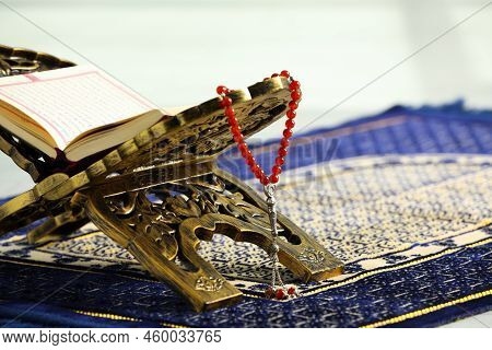 Rehal With Open Quran And Misbaha On Muslim Prayer Rug, Closeup