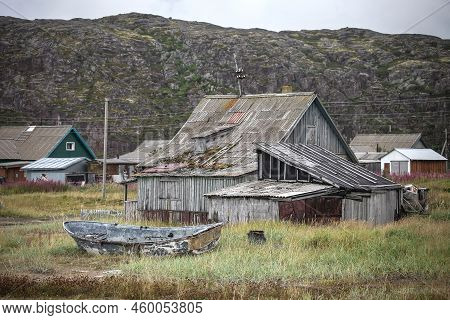Broken Boat Near The Abandoned Wooden Building