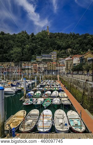 View Of Colorful Fishing Boats On La Concha Bay With Monte Urgull In The Background In San Sebastian