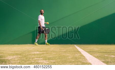 Padel Player With Black Racket Playing A Match In The Open Behind The Net Court