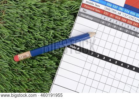 Golf Scorecard And Pencil With Eraser Laying On Grass