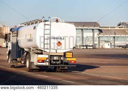 Back View Small Modern Fuel Tanker Truck Driving On Airfield Taxiway For Aircraft Refueling. Cistern