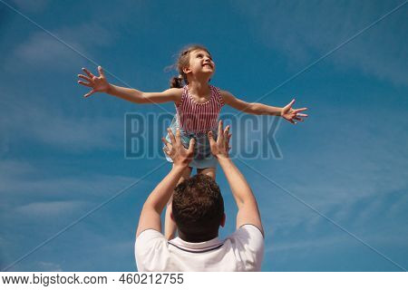 Little Girl 5 Years Flies Out Of Daddys Hands Against Blue Sky