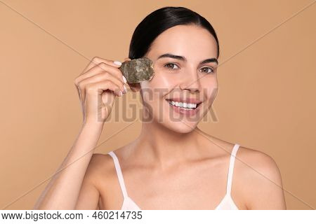 Beautiful Young Woman With Green Tea Bag On Beige Background. Skin Care