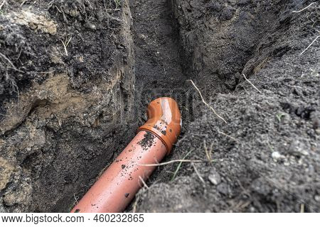 An Orange Plastic Pipe From A Septic Tank With A Diameter Of 160 Mm Lying In A Ditch.
