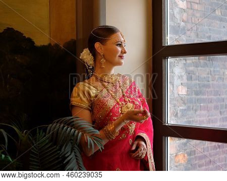 Indian Wedding. Portrait Of Attractive Hindu Bride With Rich Jewelry And Deep Dark Eyes