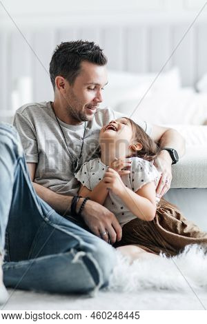 Little Cheerful Daughter Has Fun And Plays With Her Dad. Happy Dad Hugs His Little Daughter And Rejo
