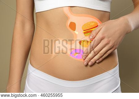 Woman With Image Of Stomach Full Of Junk Food Drawn On Her Belly Against Beige Background, Closeup. 