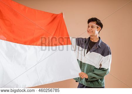 Male Athelete From Indonesia Holding Indonesian Flag Proudly