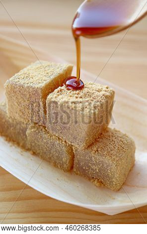 Mouthwatering Japanese Traditional Confection Called Warabimochi Being Poured On Top With Kuromitsu 